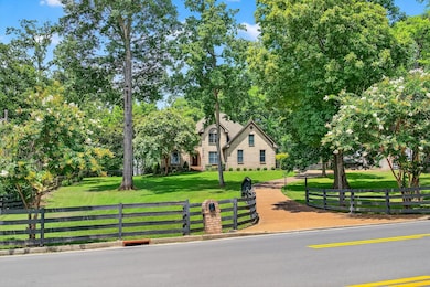 Lush emerald green grass framed by classic 4 wood plank-fencing that adds charm and privacy.