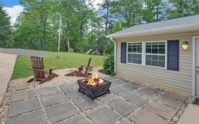 View of patio with a fire pit and a playground