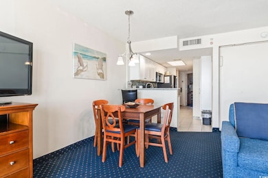 Dining area featuring a chandelier, light tile patterned floors, and a textured ceiling