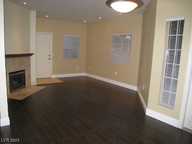 Unfurnished living room featuring baseboards, wood