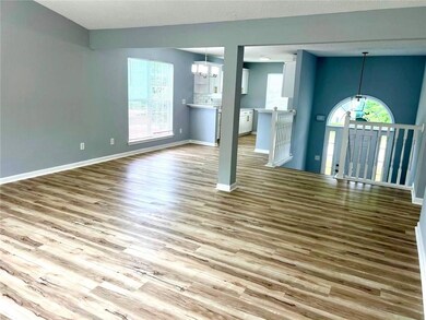 Unfurnished living room with a chandelier, wood finished floors, and plenty of natural light