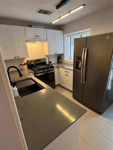 Kitchen featuring fridge, stove, extractor fan, w