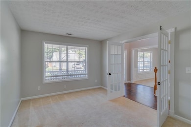Carpeted empty room featuring baseboards, visible 