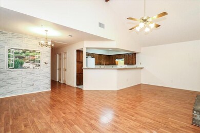 Unfurnished living room with sink, high vaulted ce