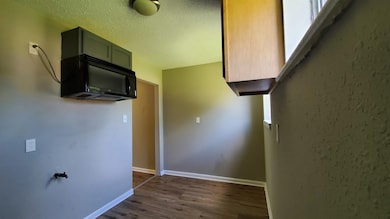 Hall featuring dark wood finished floors and a textured ceiling