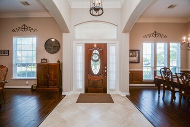 Entryway with high ceilings and plenty of natural light opens to study and dining room