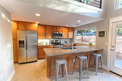 Kitchen with a sink, brown cabinetry, stainless s
