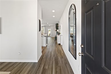 Entry with dark wood-style floors, baseboards, and