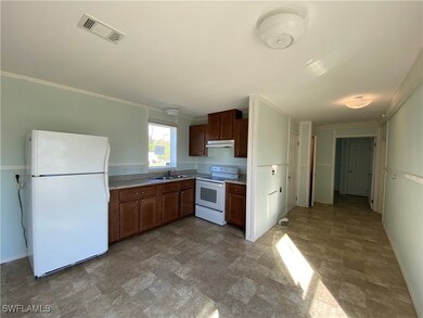 Kitchen with sink, white appliances, and ornamental molding
