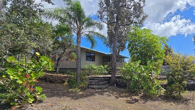 Lush tropical foliage and mature trees surround this beautiful home. Stacked rock accents and easy-care landscaping provide privacy and natural beauty in a serene island setting.