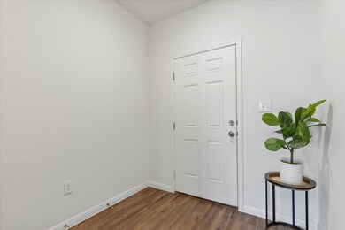 Foyer with dark wood-style floors and baseboards