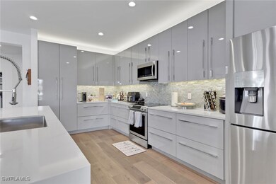 Kitchen with appliances with stainless steel finishes, decorative backsplash, light wood finished floors, modern cabinets, and recessed lighting