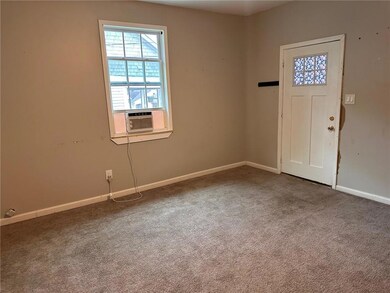 Carpeted foyer entrance featuring cooling unit and baseboards