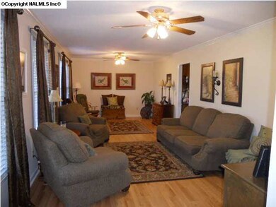 The great room has beautiful hardwood floors with two ceiling fans.