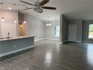 Unfurnished living room with vaulted ceiling, a si
