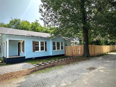 View of front facade featuring crawl space, a porch, a shingled roof, and gravel driveway