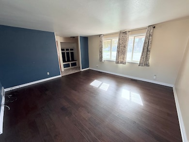 Empty room with dark wood-type flooring and a textured ceiling