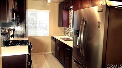 Remodeled kitchen with dark wood cabinets, stone c