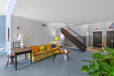 Living room with concrete floors, stairway, crown
