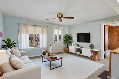 Living room with a ceiling fan and light colored carpet