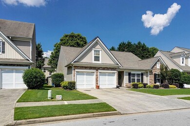 Craftsman-style home featuring stone siding, a front yard, concrete driveway, and board and batten siding