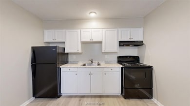 Kitchen with black appliances, under cabinet range