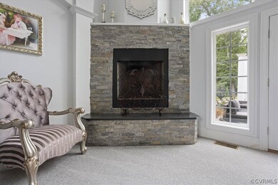 Sitting room featuring a fireplace, carpet, and a