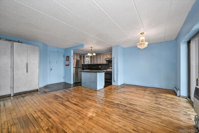 Kitchen featuring hanging light fixtures, a center island, open floor plan, dark wood-style floors, and tasteful backsplash