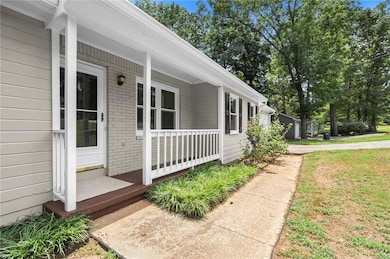 View of side of property with a porch and brick siding
