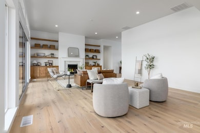 Living room with a fireplace, light wood finished floors, and recessed lighting