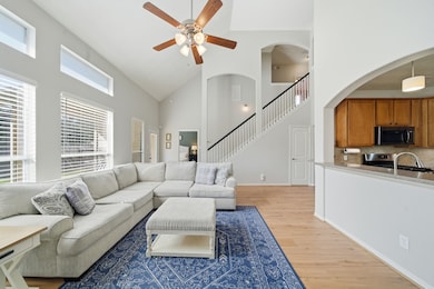 Love this wall of windows overlooking the backyard! Bright living room with tall ceilings, open access to the kitchen on the right, primary bedroom straight ahead, and stairway leading to the second floor.