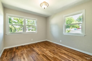 Bedroom with plenty of natural light and dark wood-style floors