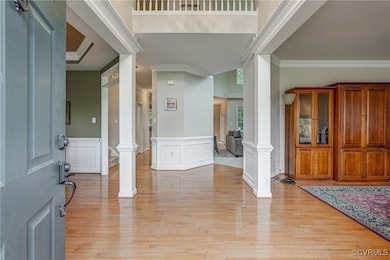 Foyer featuring decorative columns, ornamental mol