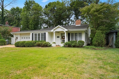 Ranch-style home with a chimney, a garage, a front lawn, concrete driveway, and roof with shingles