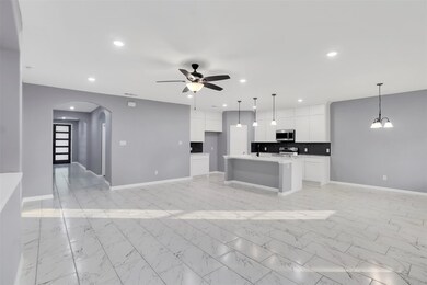 Kitchen with ceiling fan with notable chandelier, 