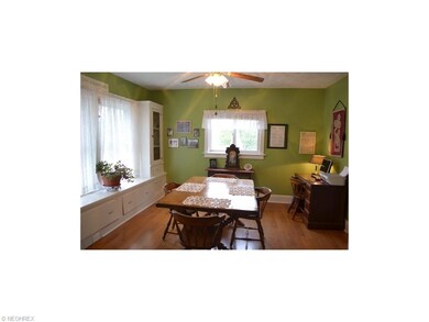 Super large formal dining room with refinished wood floors, ceiling fan, replacement windows and wonderful window seat with leaded glass cabinets and large drawers.