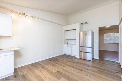 Kitchen featuring white cabinets, lofted ceiling,