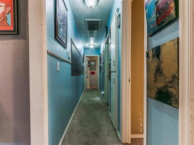 Hall featuring dark colored carpet