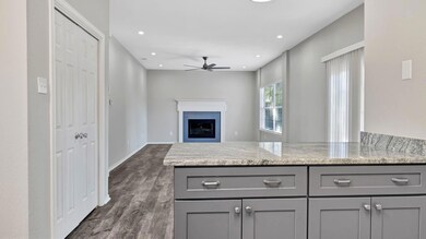 Den with kitchen at forefront. Bar type stools can