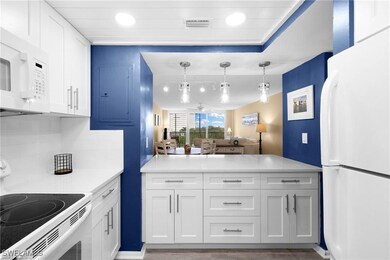 Kitchen with pendant lighting, white appliances, e