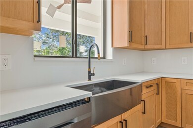 Kitchen with dishwasher, light countertops, a sink