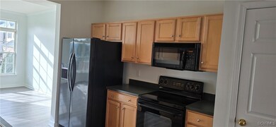 Kitchen featuring black appliances, crown molding, and hardwood / wood-style floors