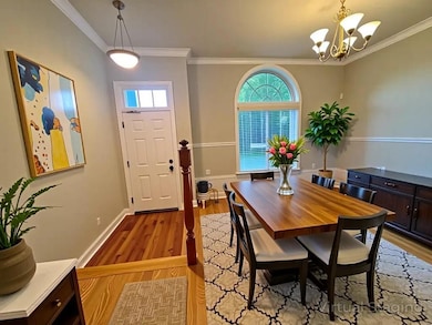 Dining space featuring crown molding, light wood finished floors, and a chandelier