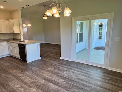 Kitchen with a chandelier, hanging light fixtures, open floor plan, and white cabinetry