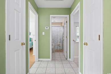 Hall featuring baseboards and light tile patterned flooring