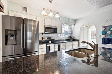 Updated, open kitchen with granite counters and st
