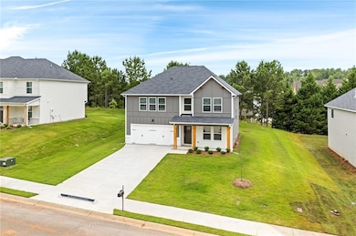 View of front of house featuring board and batten siding, a porch, driveway, a front lawn, and a garage
