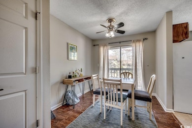 Dining area with baseboards, a textured ceiling, w