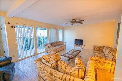 Living room featuring light tile floors and ceiling fan