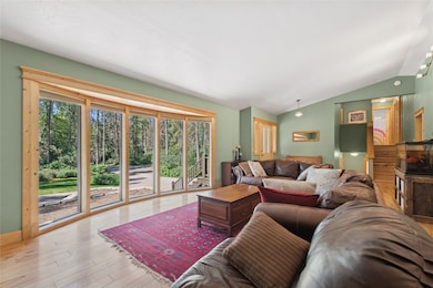 The living room features lofted ceilings, plenty of natural light, and wood finished floors